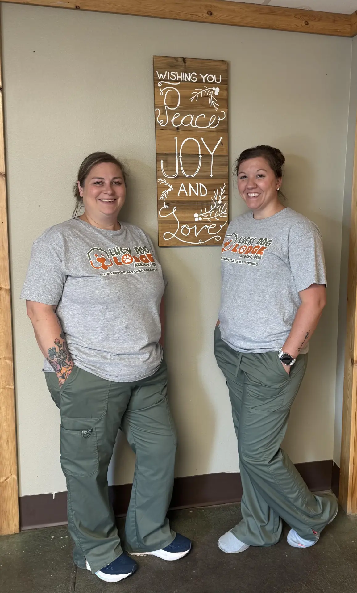 Two Lucky Dog Lodge staff members in matching Lucky Dog Lodge shirts inside the lodge