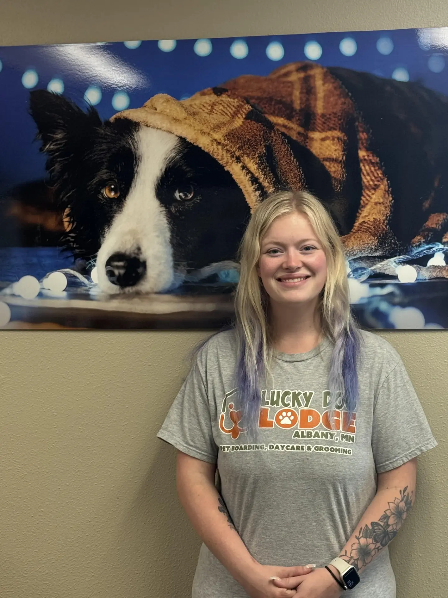 Savannah, groomer at Lucky Dog Lodge, in a Lucky Dog Lodge shirt inside the lodge