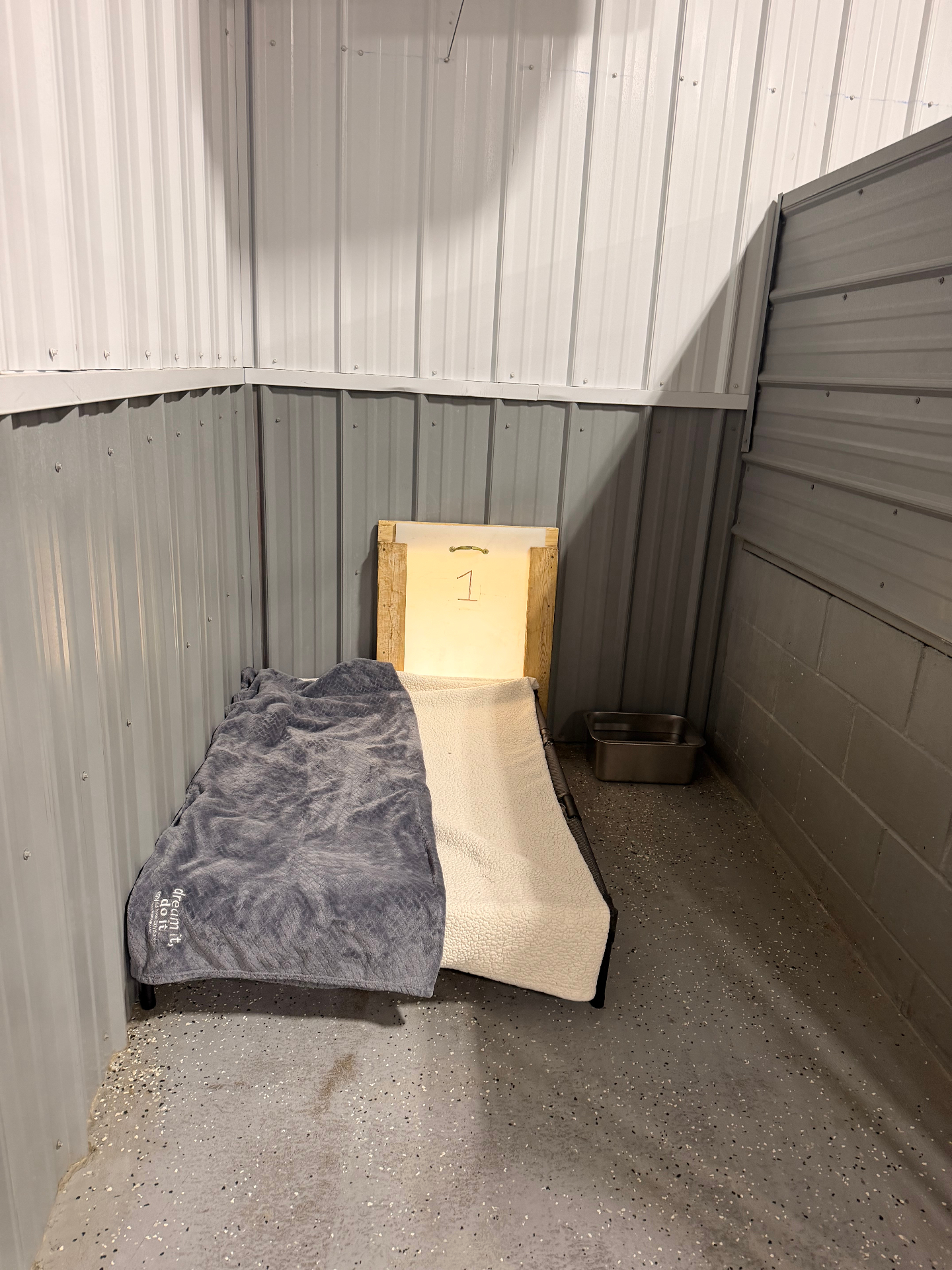 Cozy elevated dog bed with soft blankets inside a private boarding kennel at Lucky Dog Lodge